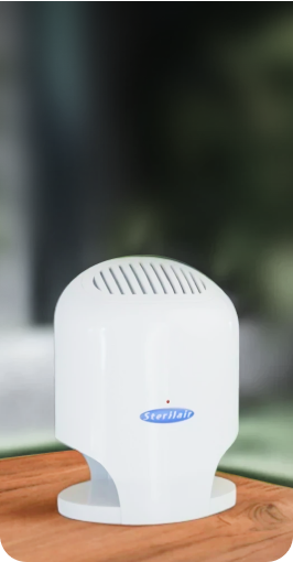Purificador de ar Sterilair branco sobre uma mesa de madeira